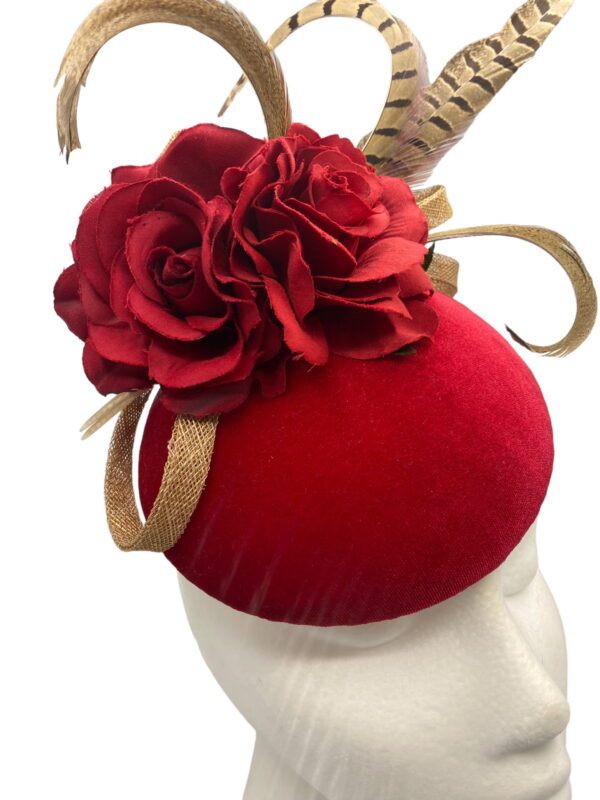 Red velvet based headpiece with red flower and finished with brown feathered detail.